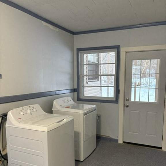 a laundry room with two washers and a dryer.