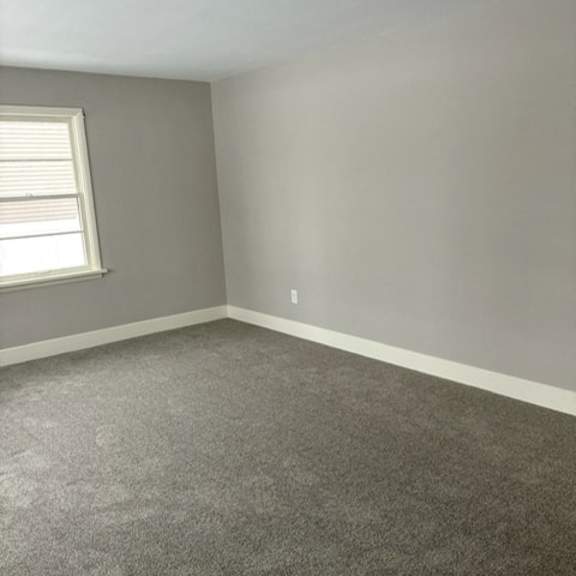 a room with a carpeted floor and a window.