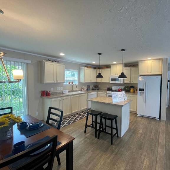 a kitchen with a table and chairs in front of it.