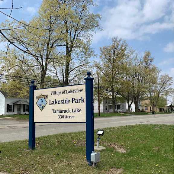 a sign for lakeside park stands in a grassy area.