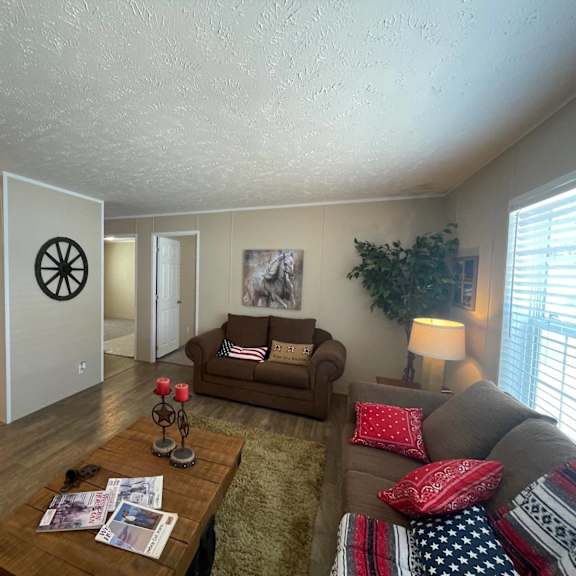 a living room with a couch, a table, and a refrigerator.