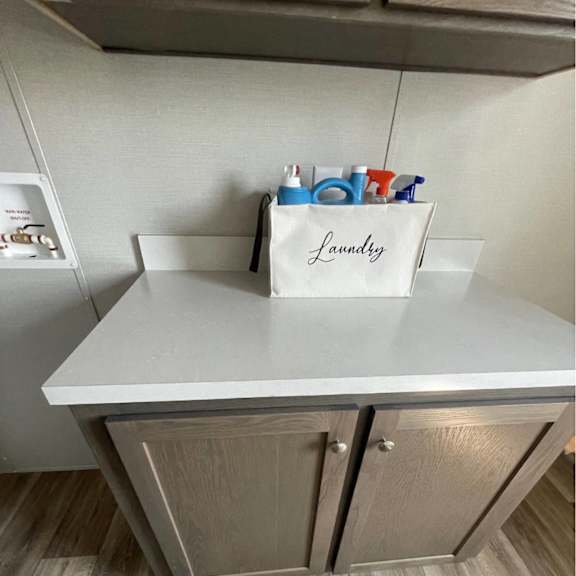 a laundry basket with clothes is on a counter.