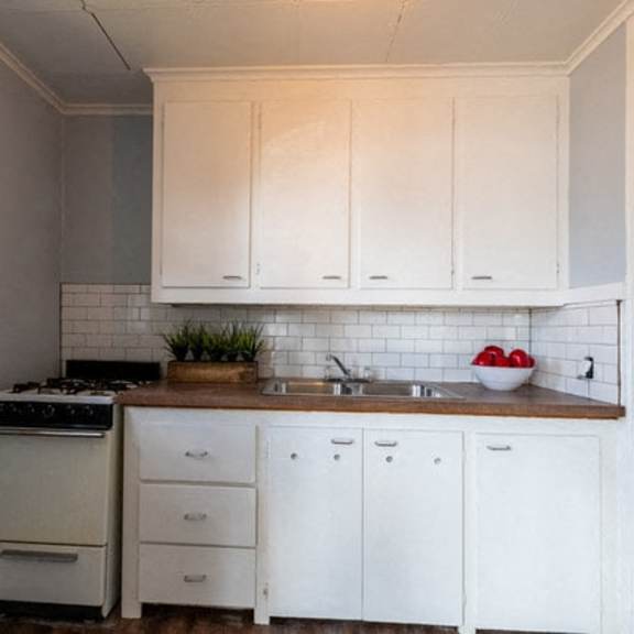 a kitchen with white cabinets and a black stove top oven.