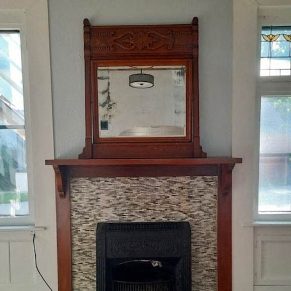 a fireplace with a mirror above it.