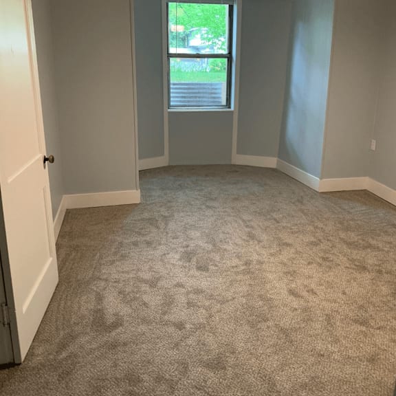 a room with a carpeted floor and a window.
