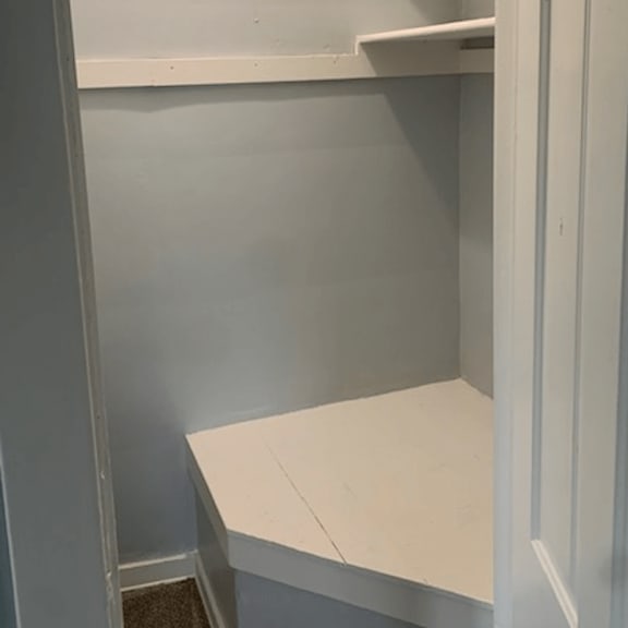 a white shelf in a room with grey walls.