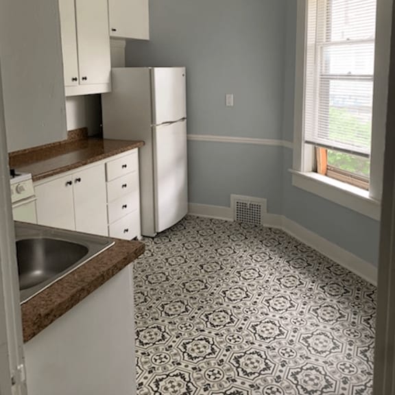 a kitchen with a patterned floor and white appliances.