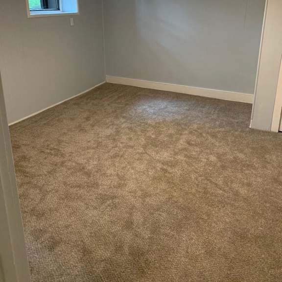 a room with a carpeted floor and a window.
