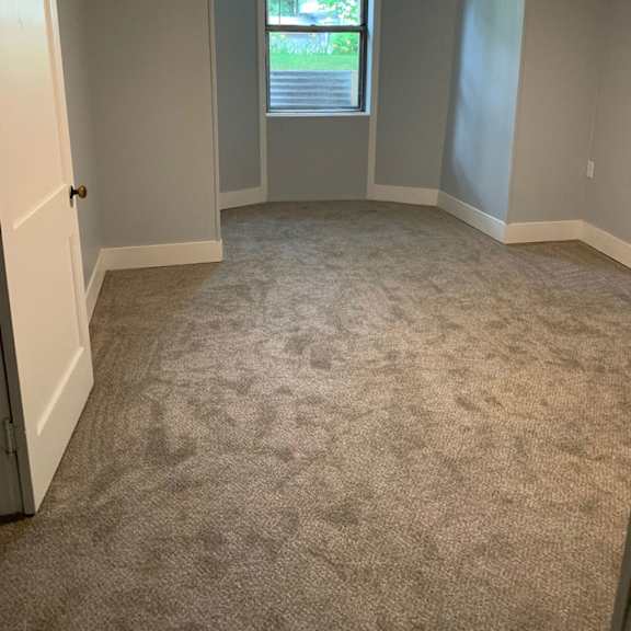 a room with a carpeted floor and a window.