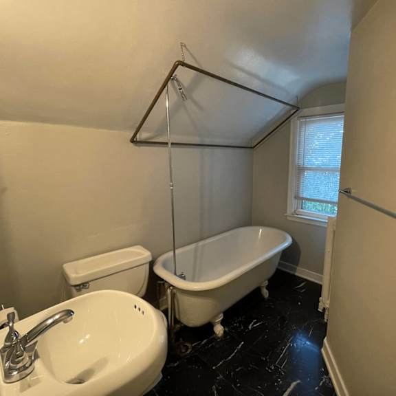 a white sink is in a bathroom with a black marble floor.