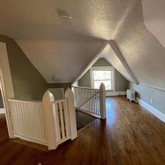 a room with wooden floors and a white railing.