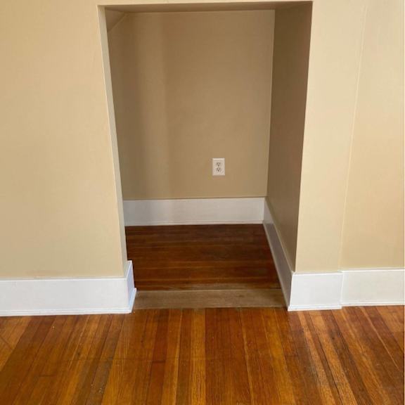 a room with a wooden floor and a white baseboard.