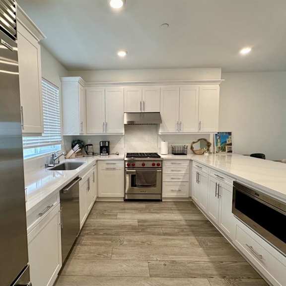 a modern kitchen with white cabinets and a central island.