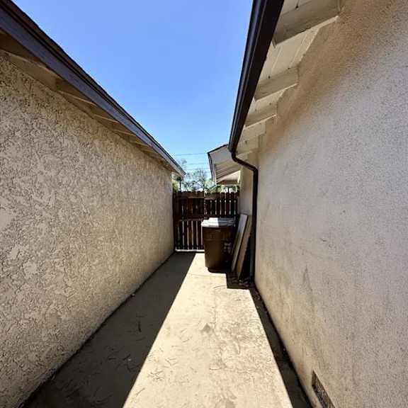 a narrow alley with a metal gate at the end.