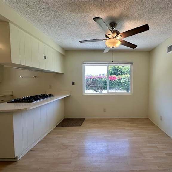 a kitchen with a window and a fan.