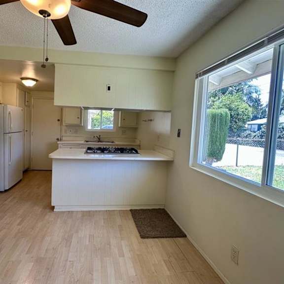 a kitchen with a white fridge and a white island.