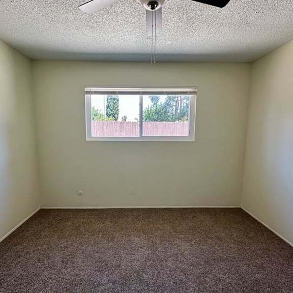 a room with a window and a ceiling fan.