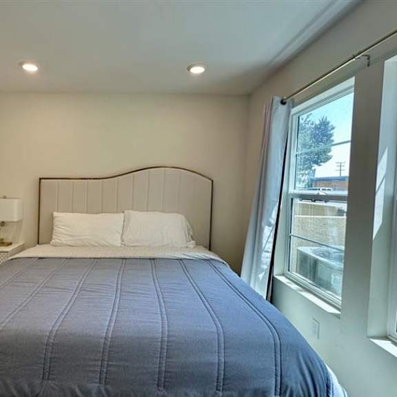 a bed with a blue cover and white pillows in a room.