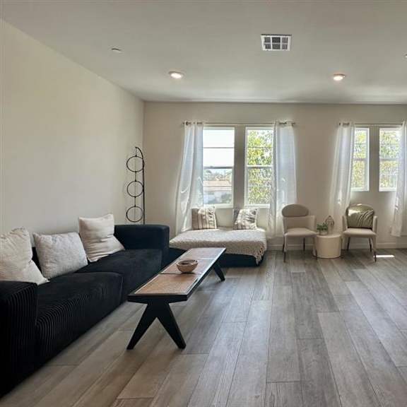 a living room with a black couch and a wooden coffee table.