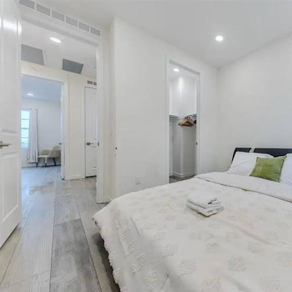 a bedroom with a large bed and a wooden floor.