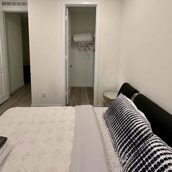 a bedroom with a bed, a nightstand, and a closet.