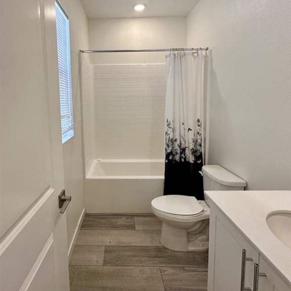 a white bathroom with a toilet, tub, and sink.
