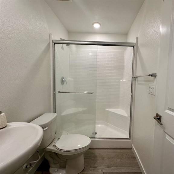 a white toilet sits next to a white sink in a small bathroom.