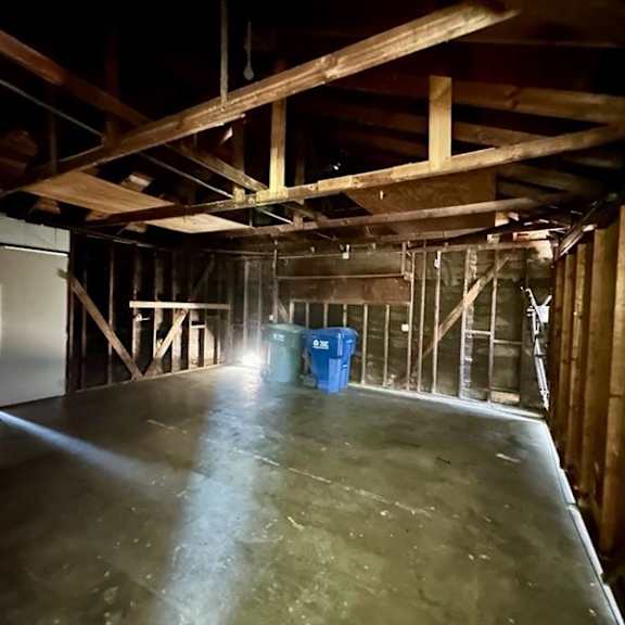 a room under construction with a blue bin in the middle.