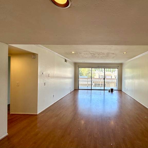 a large empty room with wooden floors and white walls.