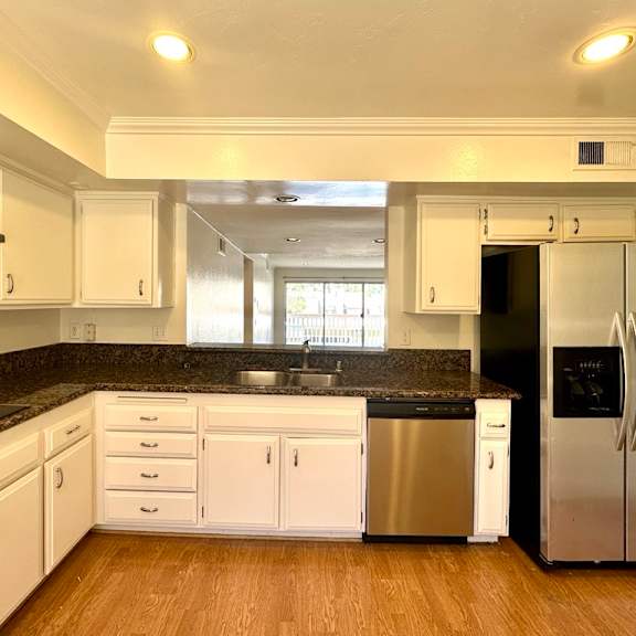 a kitchen with white cabinets and a black countertop.