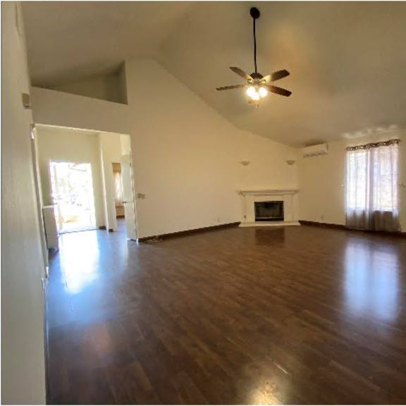 a room with a fireplace and a ceiling fan.