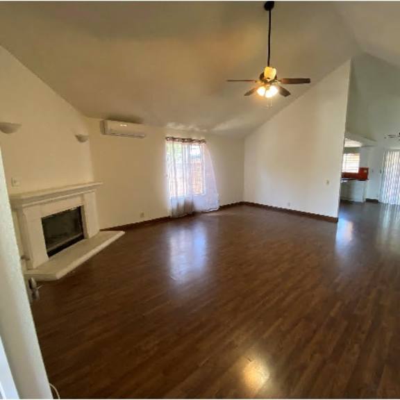 a living room with a fireplace and wood flooring.