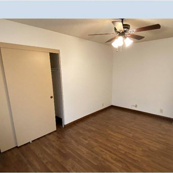 a room with a ceiling fan and a door.