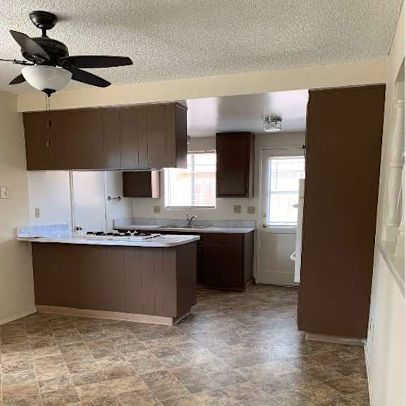 a kitchen with brown cabinets and a tile floor.