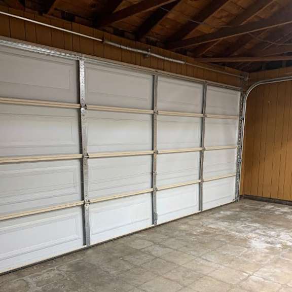 a large garage with a white door and a brown wall.
