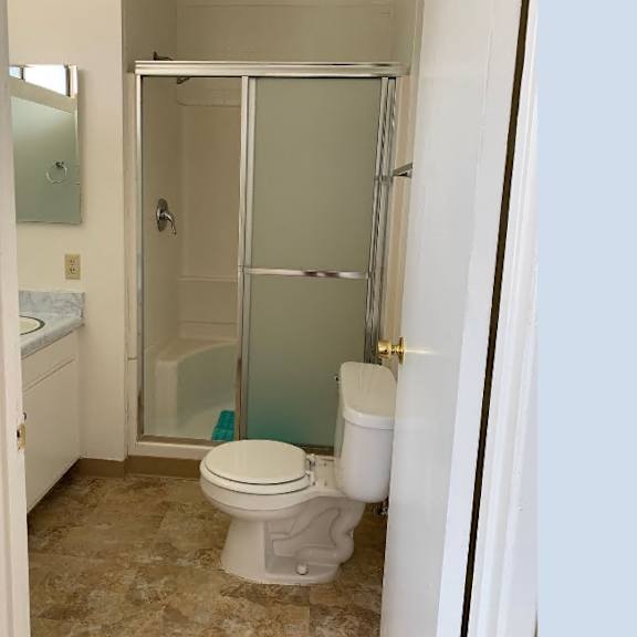 a white toilet in a bathroom with a glass shower door.