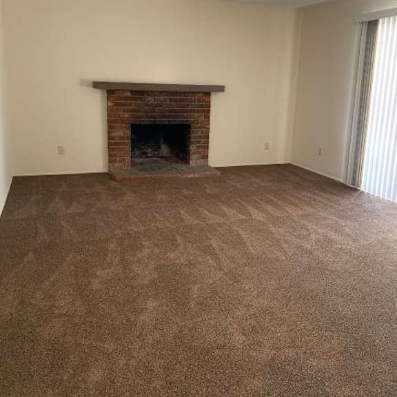 a room with a fireplace and carpeted floor.