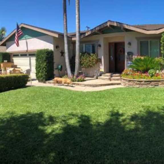 a house with a green lawn and a flag on the front.