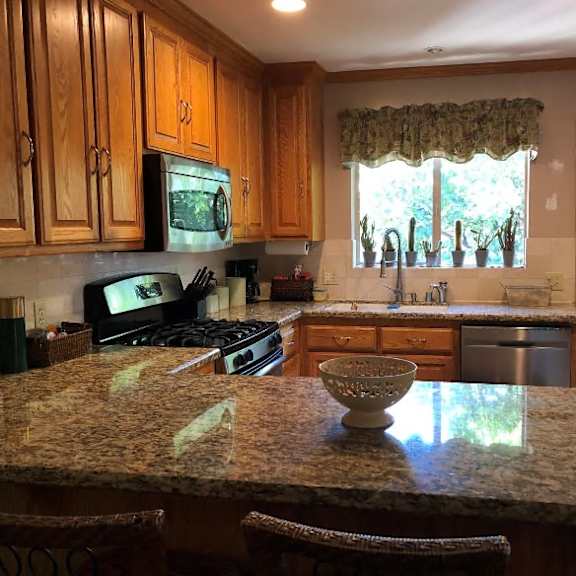 a kitchen with granite countertops and wooden cabinets.
