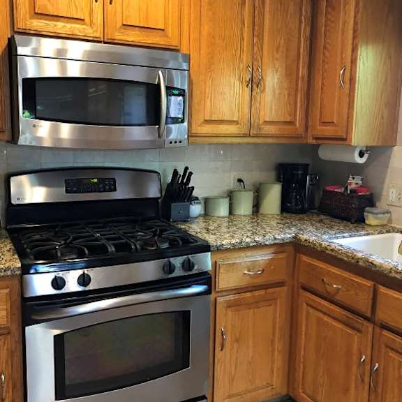 a kitchen with a stove, microwave, and wooden cabinets.