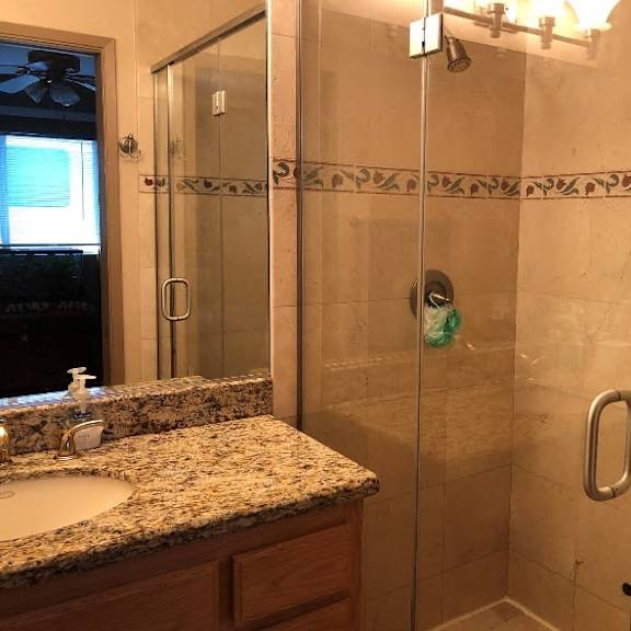 a bathroom with a sink, mirror, and shower.