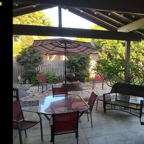 a patio with a table and chairs under a canopy.