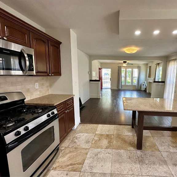a kitchen with a tiled floor and a long table.