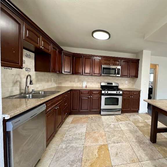 a kitchen with brown cabinets and a tiled floor.