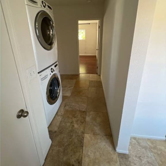a white washer and dryer in a narrow hallway.
