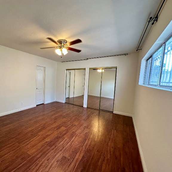 a room with wooden floors and a ceiling fan.