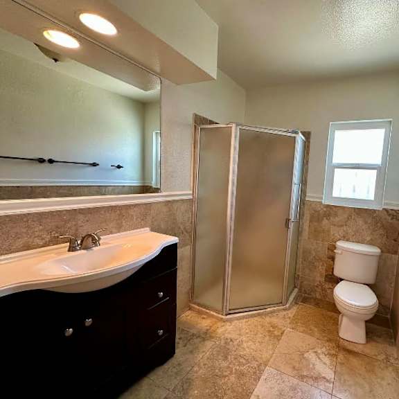 a bathroom with a sink, toilet, and shower.