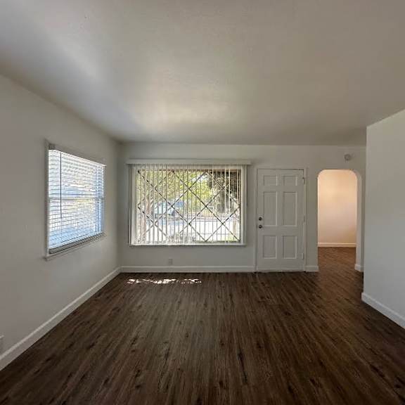a room with wooden floors and a white door.