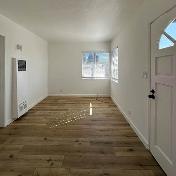 a room with wooden flooring and a door on the right.