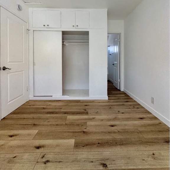 a room with a wooden floor and a white ceiling fan.